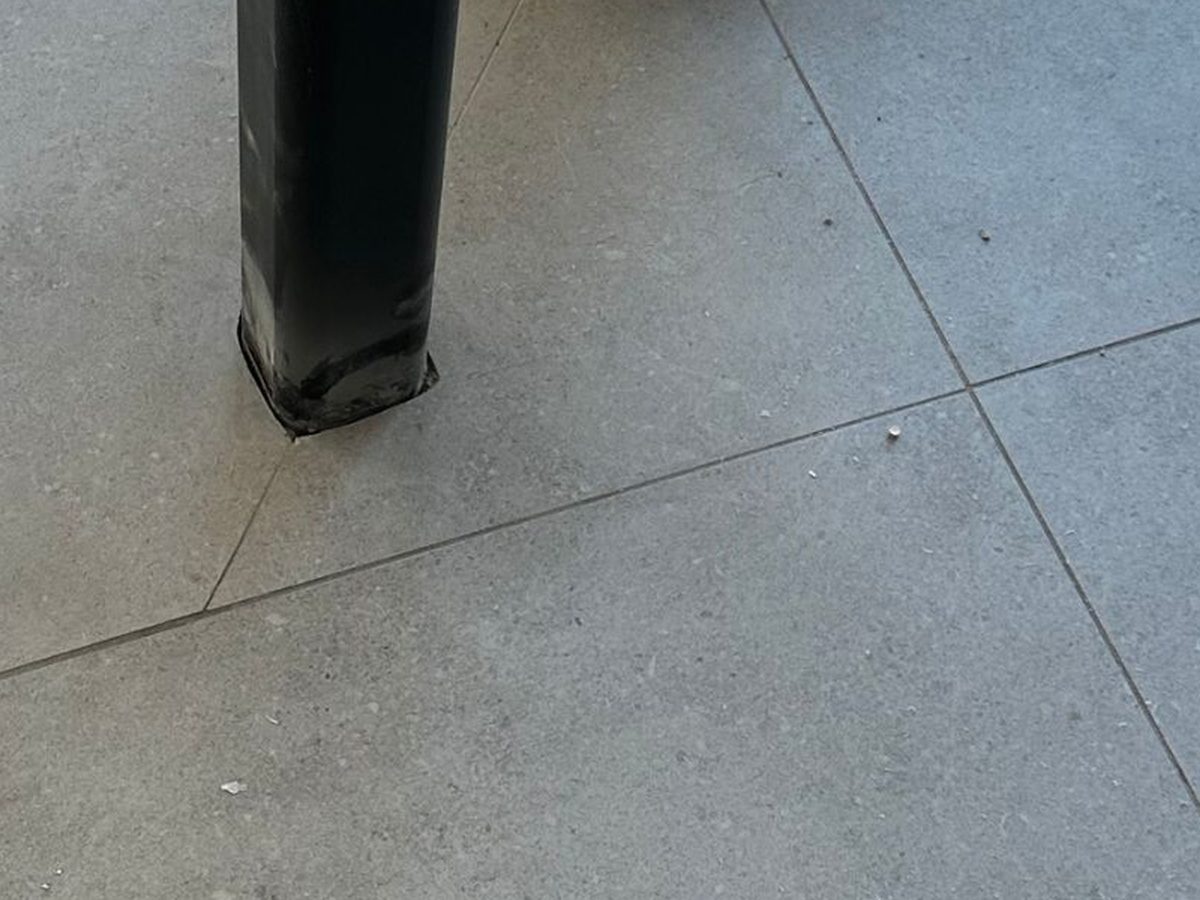 Na: vloertegel rond de paal hersteld zonder breekwerk
